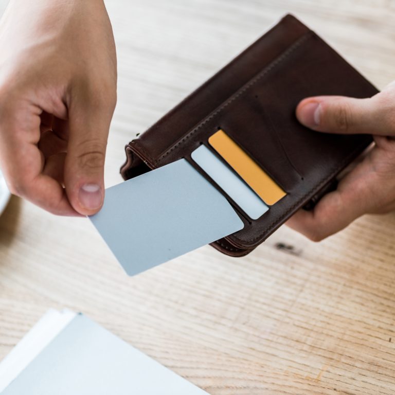 cropped view of businessman taking credit card while holding black wallet